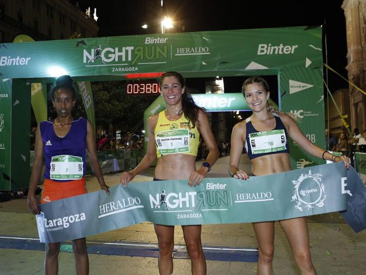 Marta Pintanel, en el centro, ganadora de la primera Binter Nightrun Zaragoza. (Foto: Heraldo de Aragón - Binter)